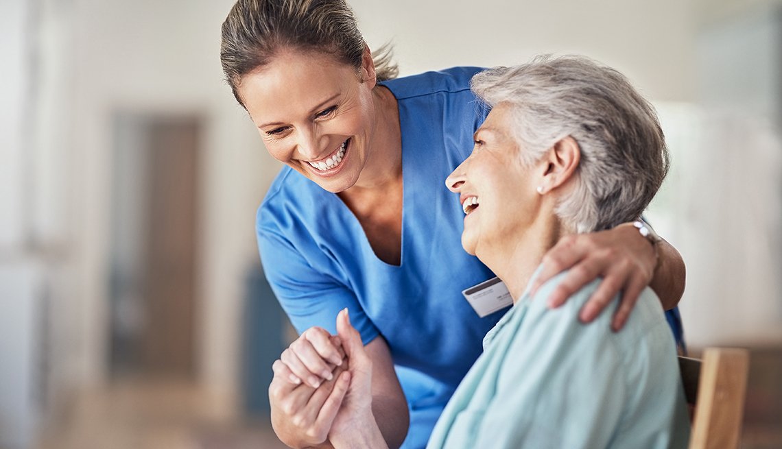 Shot of a young caregiver caring for her elderly patient in her home